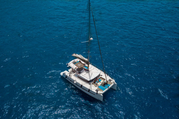 Nereus, catamarán Bali 4.0, anclado en aguas turquesas frente a Marbella — vista aérea