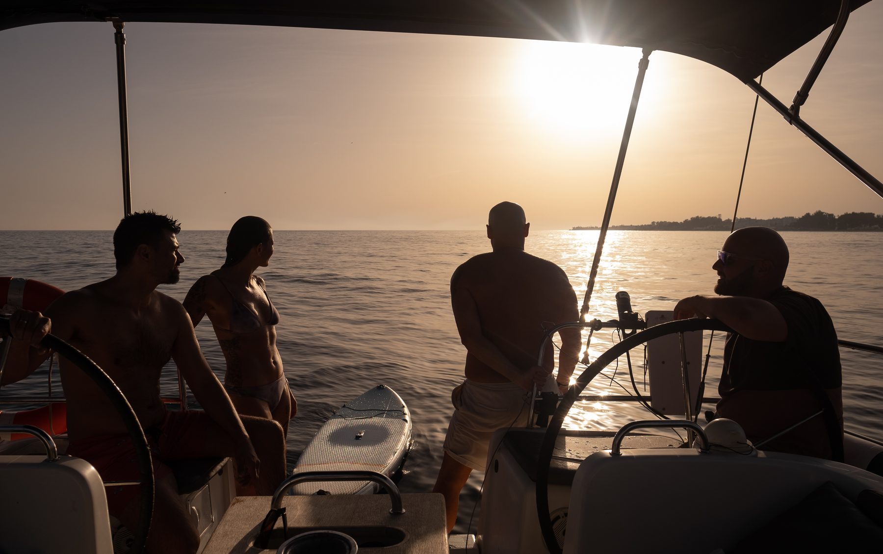 Invitados y patrón al timón al atardecer en un chárter privado desde Puerto Banús